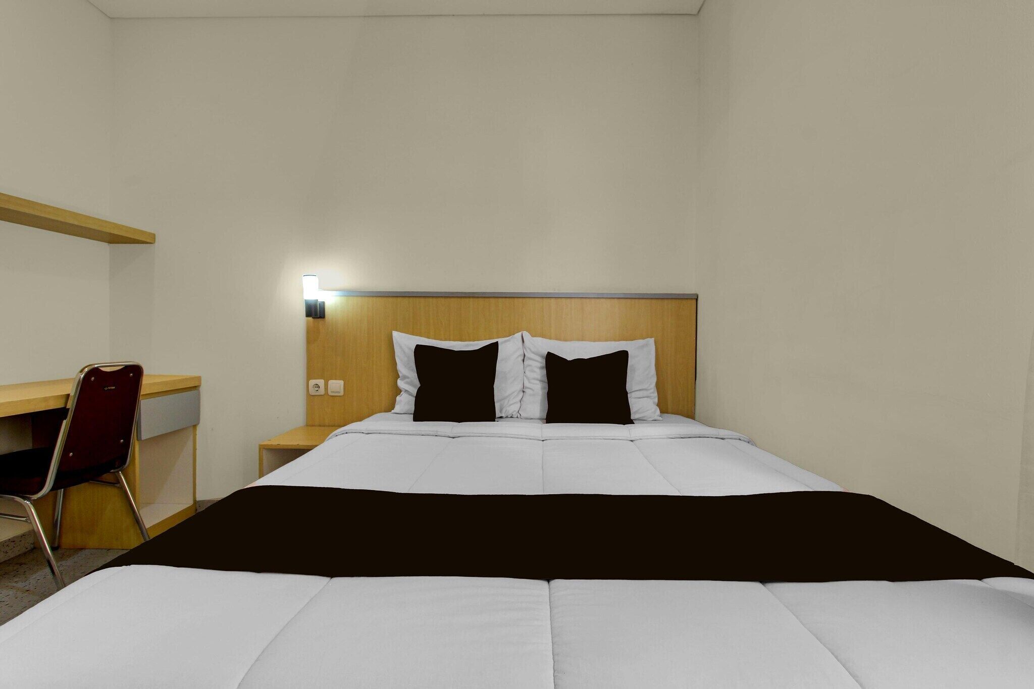 Une chambre d’hôtel avec un lit, un bureau et une chaise.