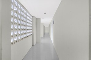 A long, narrow hallway with white walls and a ceiling.