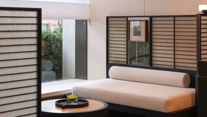 A modern room with a sofa, a small table, and a view through a window.