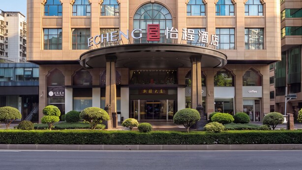 A multi-story hotel with a prominent entrance, large windows, and a clear sky.