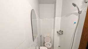 Ein kleines Badezimmer mit Waschbecken, Toilette und Dusche.