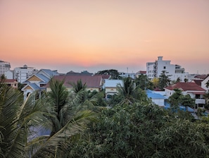 A residential area with houses, some with red roofs, and dense greenery including palm trees. - Karuna Villa & Garden (Siem Reap)