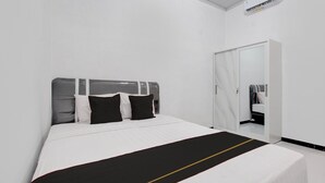 Een hotelkamer met een bed, een kledingkast en een spiegel.