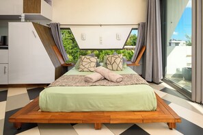 Ein modernes Schlafzimmer mit einem Bett, einem Einbauschrank und einem großen Fenster mit Vorhängen.