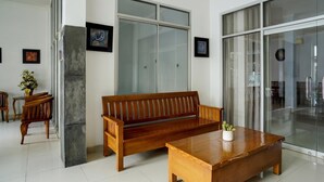 A modern interior with a wooden bench, a coffee table, and a glass door.
