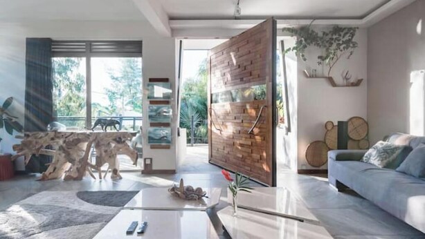 A modern living room with a large window, a wooden partition, a sofa, and a coffee table.