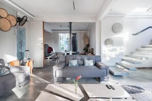 A modern living room with a grey sofa, a coffee table, and a vase with flowers.