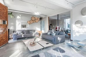 A modern living room with two sofas, a coffee table, and a fireplace.