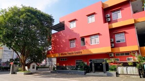 A red building with a sign reading 'Wisma Faeyza Syakira.'