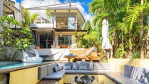 A modern house with a pool, outdoor seating, and tropical plants. - Private tropical loft in shared villa + pool + jacuzzi (Port Louis)