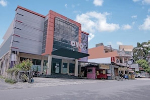A hotel with a modern facade, a prominent sign, and a covered entrance.