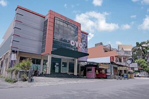 A hotel with a modern facade, a prominent sign, and a covered entrance.