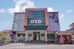 A hotel with a modern facade, a prominent sign, and a covered entrance.