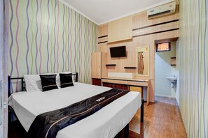 Una habitación de hotel con cama, televisión, escritorio y baño.
