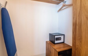 Ein kleiner Holzschrank mit einem schwarzen elektronischen Gerät darauf, einem blauen hängenden Gegenstand und einer Holzbalkenkonstruktion.