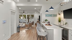 A modern kitchen with a bar area, white cabinetry, and pendant lighting. - Sleeps 18 + Pool + Hot Tub + Wet Bar | Walk to the Beach | The Salty Pearl (Santa Rosa Beach)