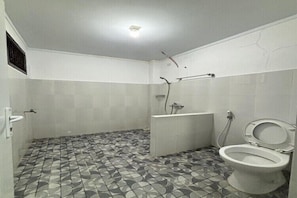 A bathroom with a patterned floor, a toilet, a shower, and a bathtub.