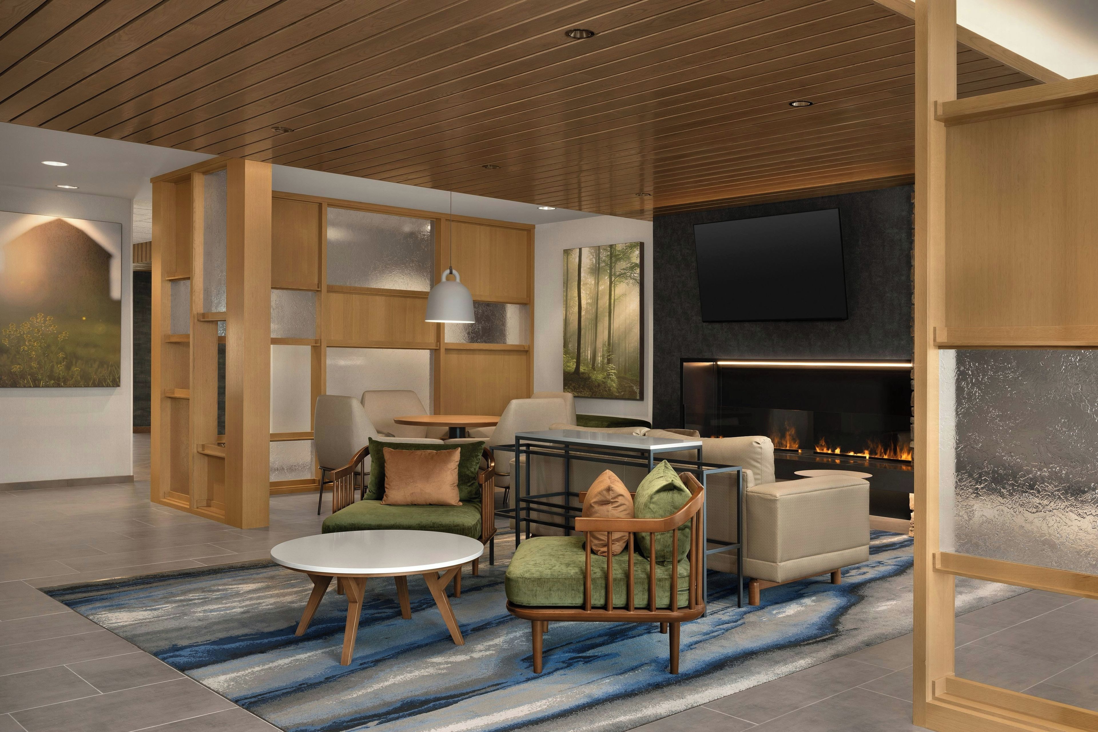A modern living room with a fireplace, comfortable seating, and a large TV screen.
