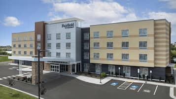A multi-story Fairfield by Marriott hotel with a modern facade, a covered entrance, and a parking lot with handicapped and electric vehicle spaces.
