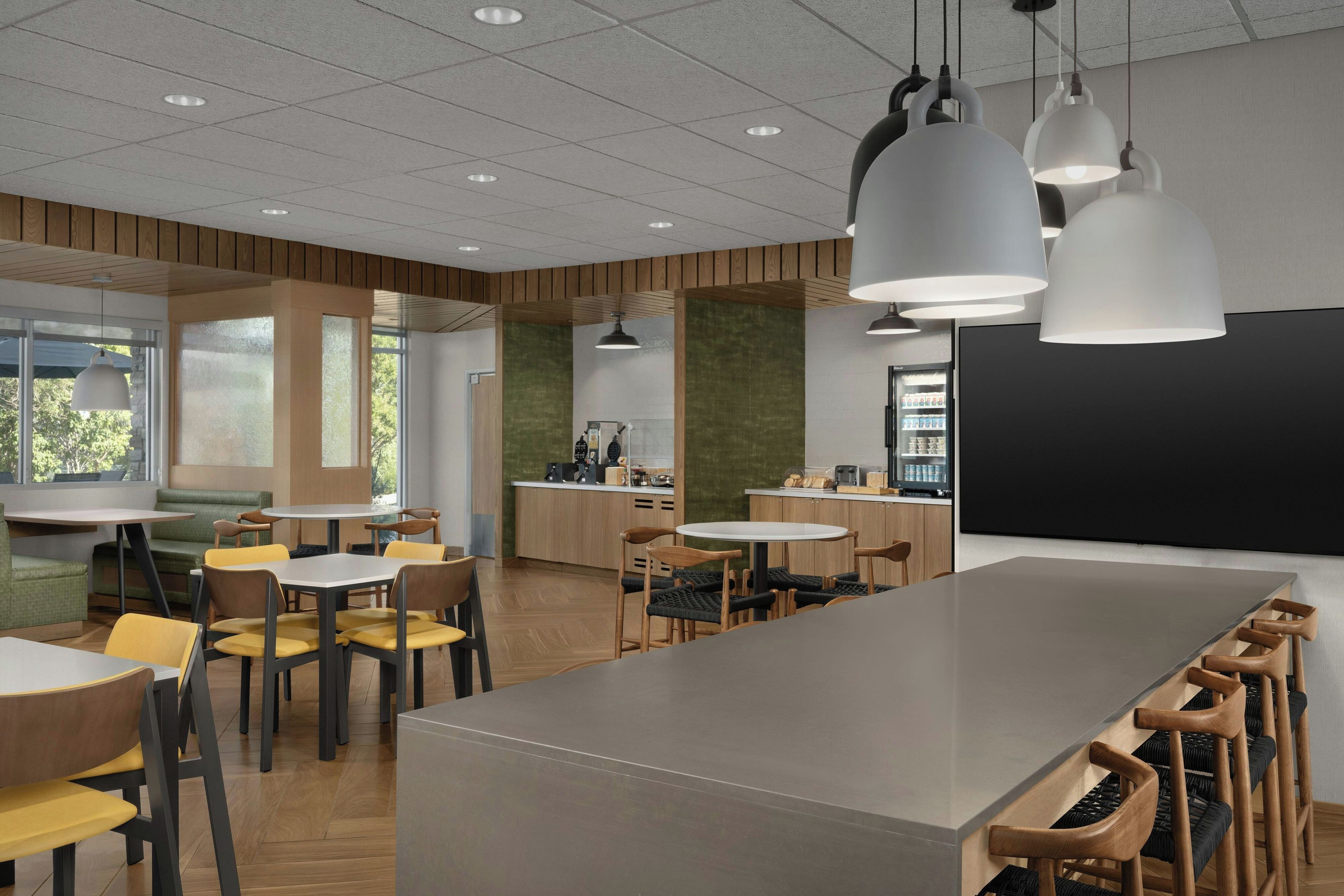 A modern interior with a central island table, seating arrangements, and a blackboard.