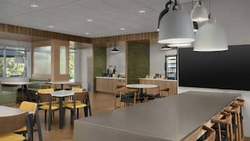 A modern interior with a central island table, seating arrangements, and a blackboard.