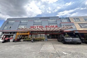 A hotel with a covered entrance, a parking area with motorcycles, and a sign for 'HOTEL POMA'. - Relaxing Stay at Medina House (Banda Aceh)