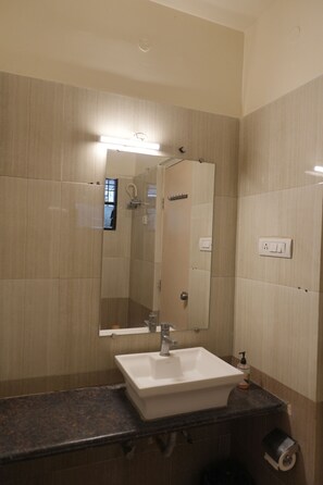 A bathroom with a sink, mirror, and light fixture.