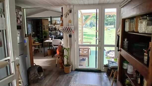 Une cuisine spacieuse avec des meubles en bois, un coin repas et une vue sur l’extérieur.