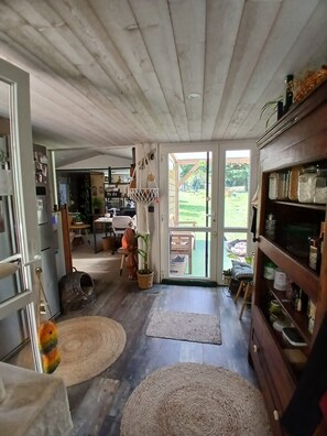 A spacious kitchen with wooden cabinets, a dining area, and a view of the outdoors.