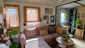 Un salon chaleureux avec un canapé, une petite table et divers objets de décoration.