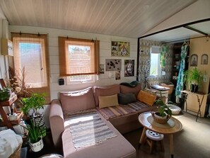 Ett mysigt vardagsrum med en soffa, ett litet bord och diverse dekorativa föremål.