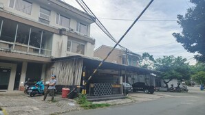 A building with multiple floors, a covered outdoor area, and a parked scooter. - Barkah Balikpapan Std Double (Balikpapan)