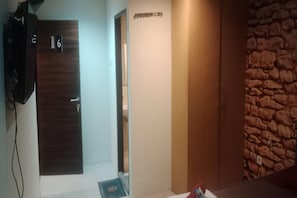 A room with a wooden door marked '16', a stone wall, and a door with a sign above it.