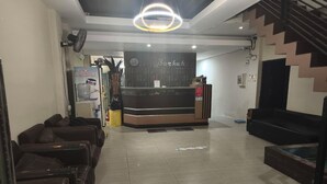 A hotel lobby with a reception desk, seating area, and a staircase. - Barkah Balikpapan Std Double (Balikpapan)