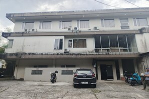 Un bâtiment à deux étages, doté d’un toit plat, de nombreuses fenêtres et d’une entrée fermée par un portail.