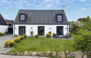 A two-story house with a sloped roof, large windows, and a well-maintained lawn. - Gorgeous home in Samsø with WiFi (Samsø)