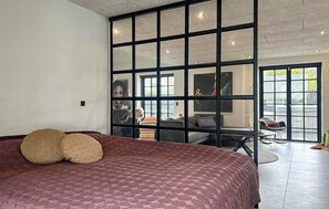 A bedroom with a large bed, a sliding glass door leading to a living area, and a view of the outside. - Gorgeous home in Samsø with WiFi (Samsø)