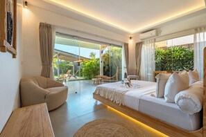 Un dormitorio moderno con una cama grande, un sofá, una silla y vistas al exterior.