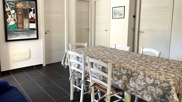 Un espace repas comprenant une table, des chaises et des œuvres d’art accrochées au mur.