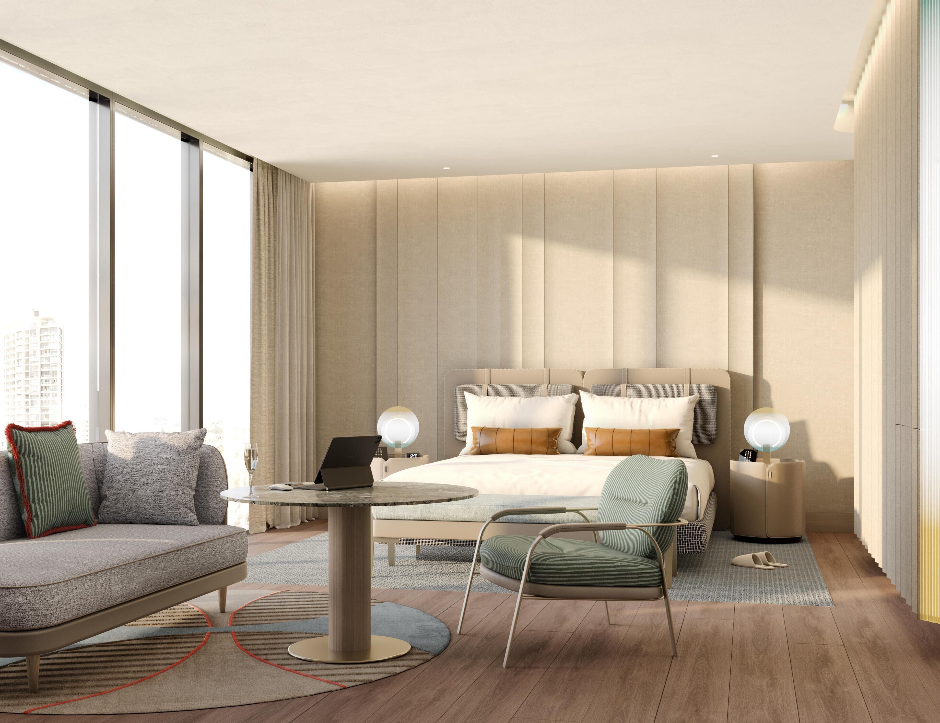 A modern hotel room with a large bed, a sitting area with a table, and a view of the city.