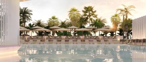 A pool area with lounge chairs and umbrellas, surrounded by palm trees.
