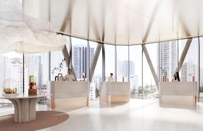 A spacious lobby with high ceilings, large windows, and a modern design.