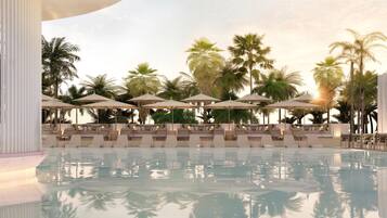 Un área de piscina con sillas de descanso y sombrillas, rodeada de palmeras.