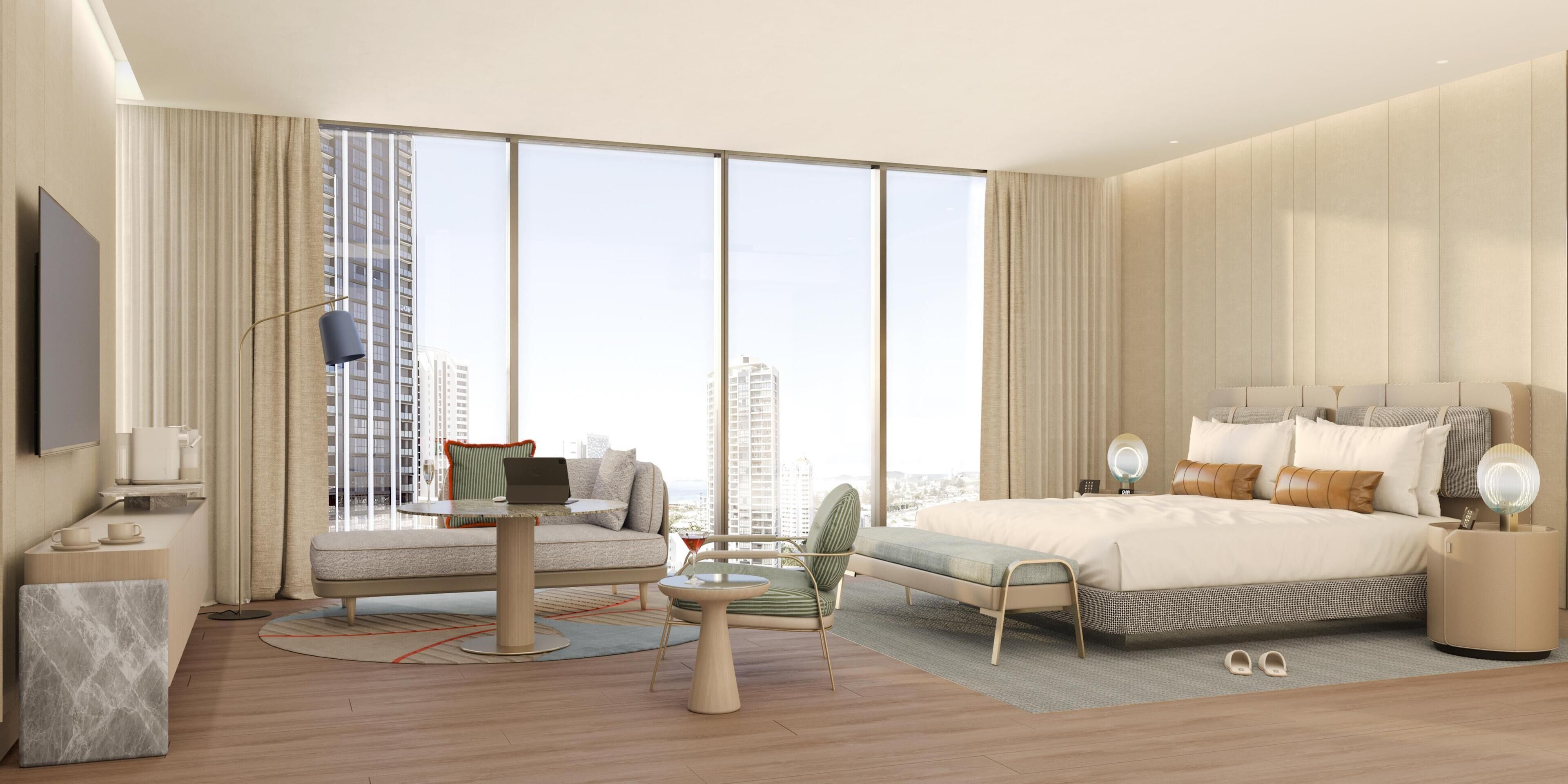 A modern hotel room with a large bed, a seating area with a laptop, a TV, and a view of the cityscape.
