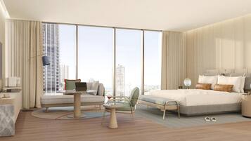 A modern hotel room with a large bed, a seating area with a laptop, a TV, and a view of the cityscape.
