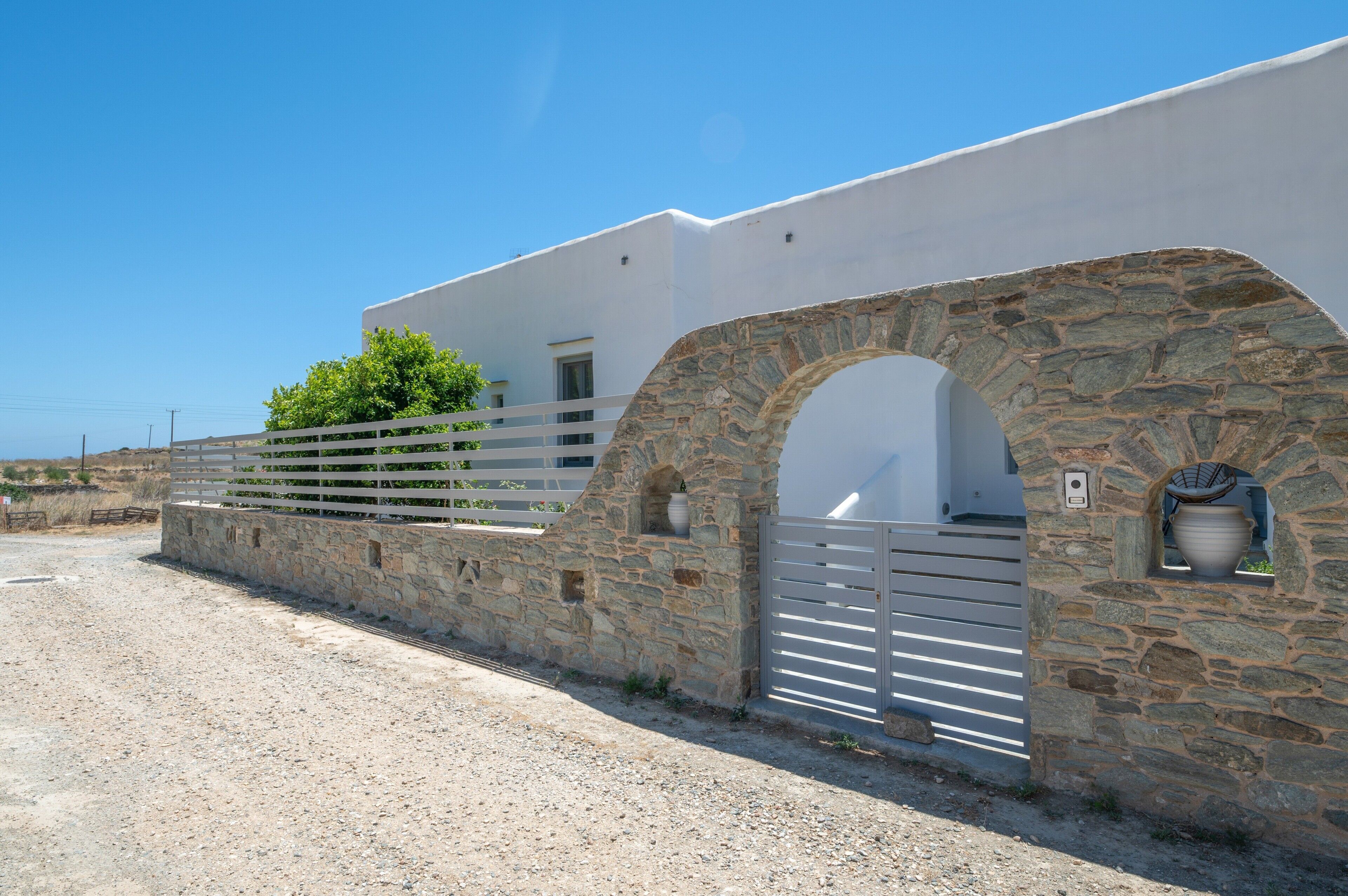 A building with a stone facade, white walls, and a gated entrance.