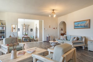 A spacious living room with a sofa, armchairs, a coffee table, and a bookshelf. - Villa Fotis Country House with Sea View, Wi-Fi, and Air Conditioning (Megas Gialos)