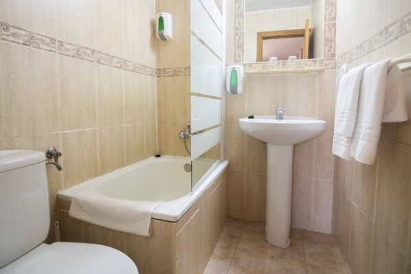 A bathroom with a bathtub, toilet, sink, and towel rack.