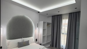 Ein modernes Hotelzimmer mit einem großen Bett, eingebauten Regalen und einem Oberlicht.