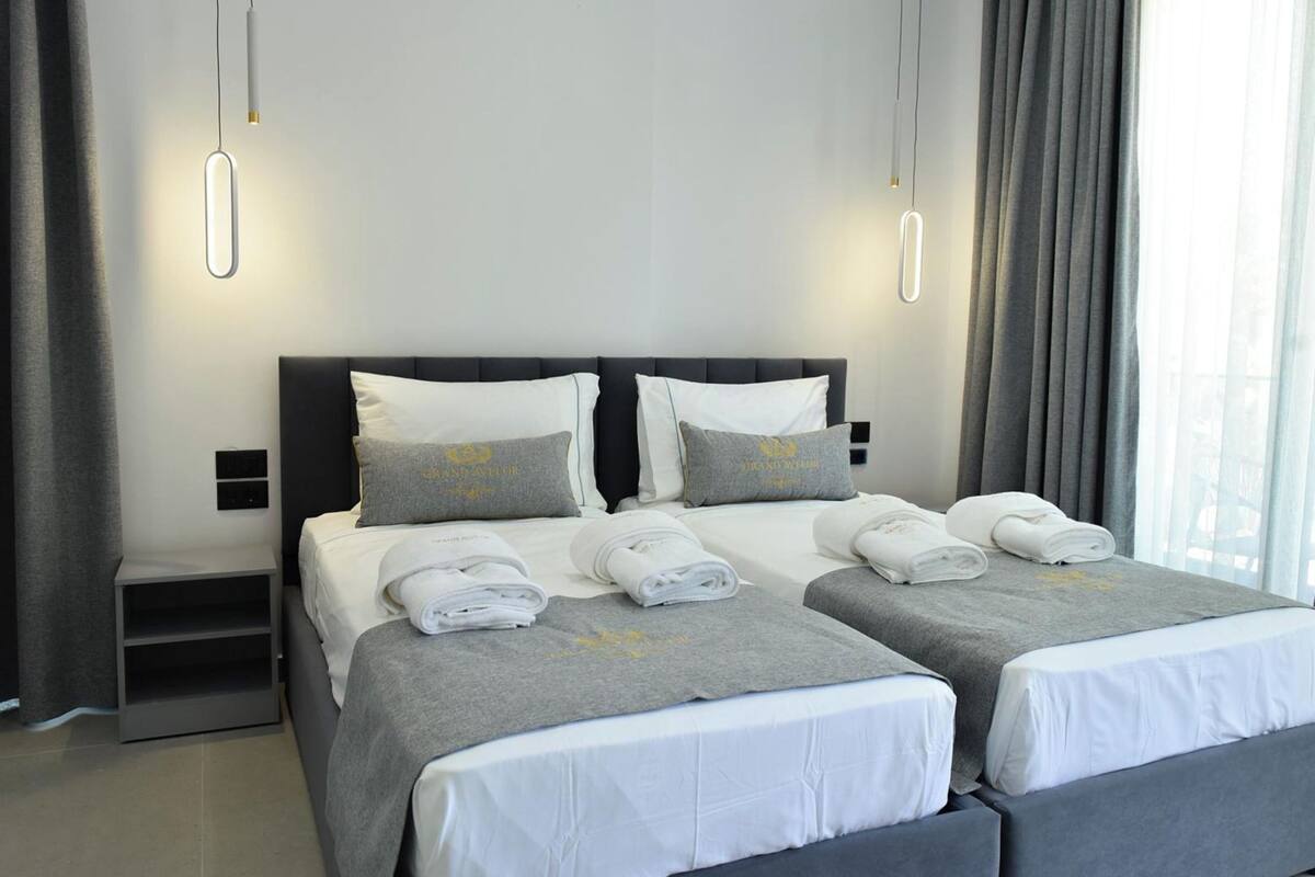 A double bed with two pillows, a bedside table, and a nightstand.